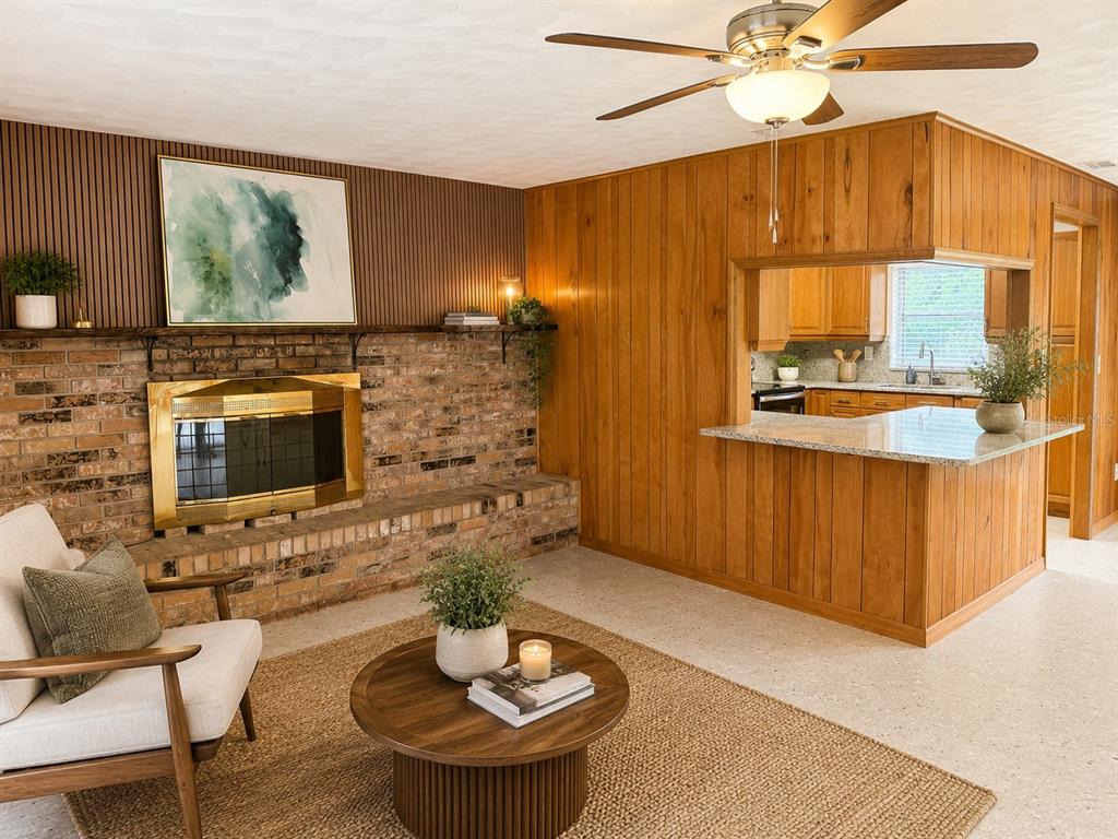 A living room features a brick fireplace, wood-paneled walls, and an open kitchen pass-through — 13895 SE 100TH AVENUE, SUMMERFIELD, FL