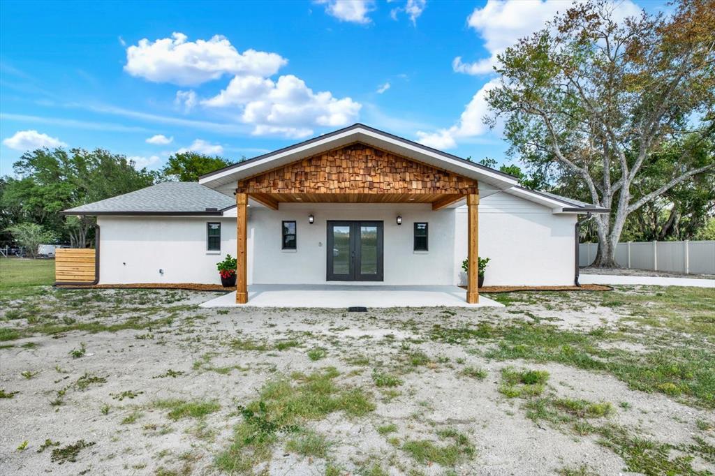 A white house with a wooden shingle gable and a covered front porch entrance — 2515 RAGINS LANE, PLANT CITY, FL