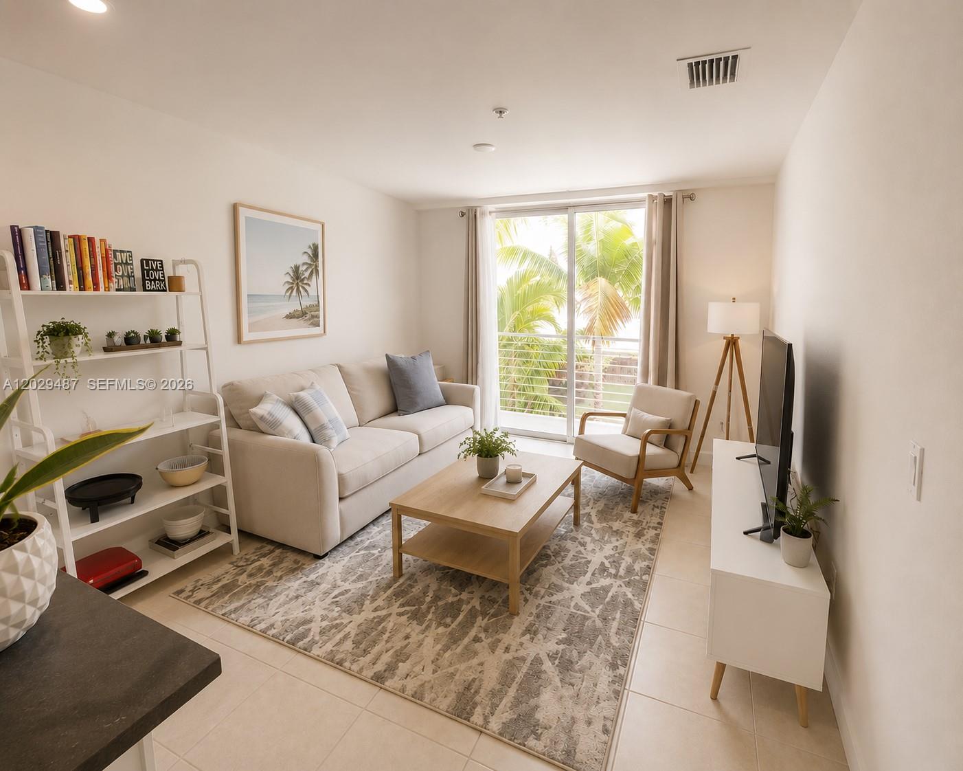 A bright living room features a beige sofa, wooden coffee table, and a sliding glass door — 945 Michigan Ave # 5, Miami Beach FL 33139, MIAMI BEACH, FL