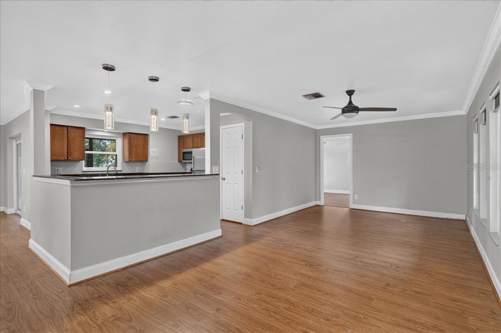 A kitchen with wood cabinets and a breakfast bar opens into a spacious living area — 1221 E LIME STREET, TARPON SPRINGS, FL