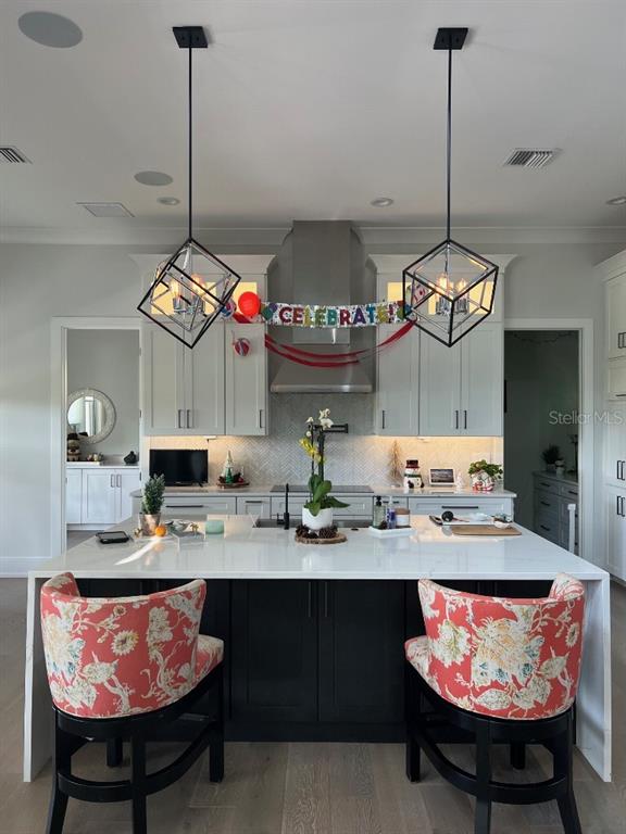 A kitchen features a large white island with two floral barstools under geometric pendant lights — 790 CORDOVA BOULEVARD NE, ST PETERSBURG, FL