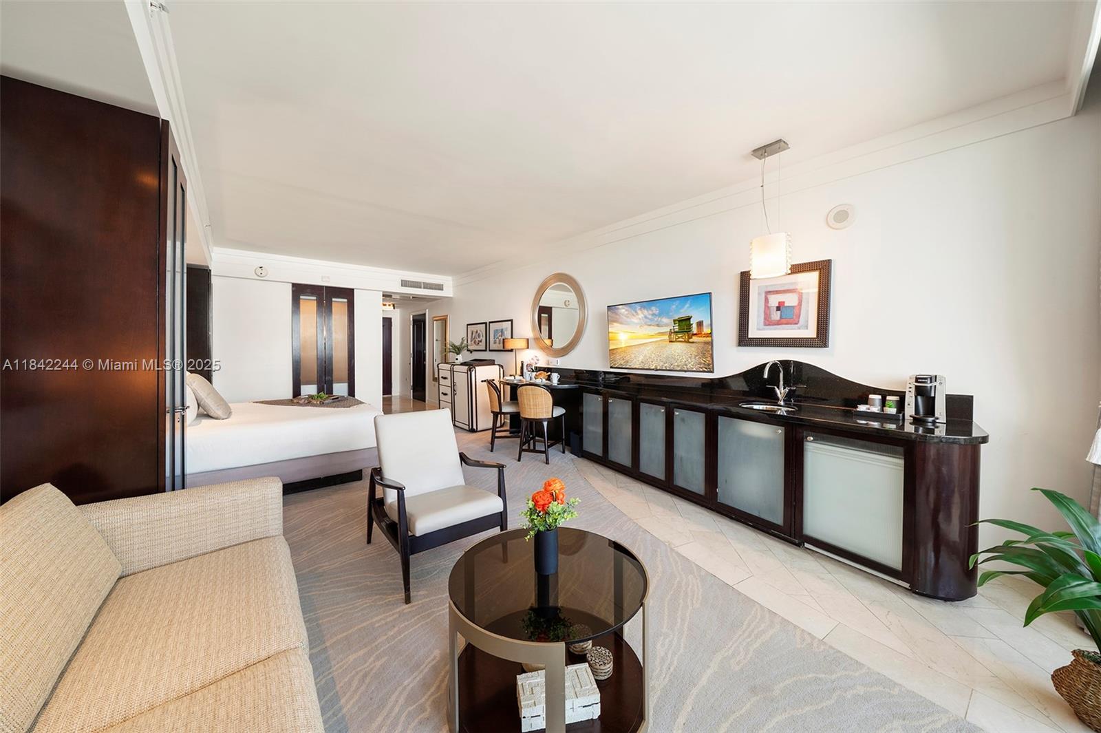A hotel room features a bed, a seating area, a kitchenette, and a flat-screen television — 4391 Collins Ave # 802, Miami Beach FL 33140, MIAMI BEACH, FL