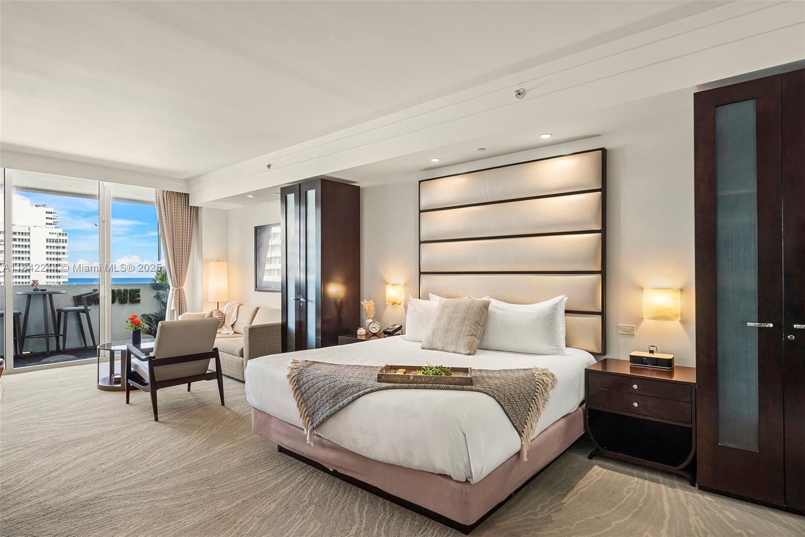 A bedroom features a king bed, a seating area, and a balcony with ocean views — 4391 Collins Ave # 802, Miami Beach FL 33140, MIAMI BEACH, FL