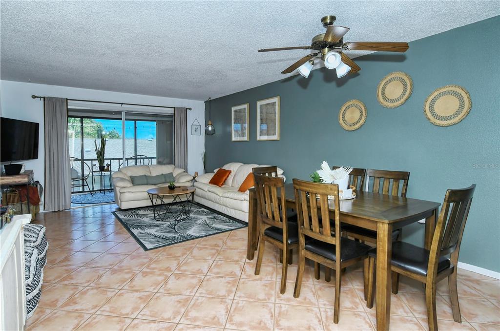 A living and dining area features tile floors, a teal accent wall, and a ceiling fan — 116 VISTA HERMOSA CIRCLE UNIT 308C, SARASOTA, FL