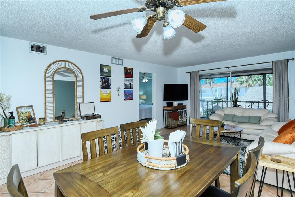 A dining area with a wooden table opens into a living room with a ceiling fan — 116 VISTA HERMOSA CIRCLE UNIT 308C, SARASOTA, FL
