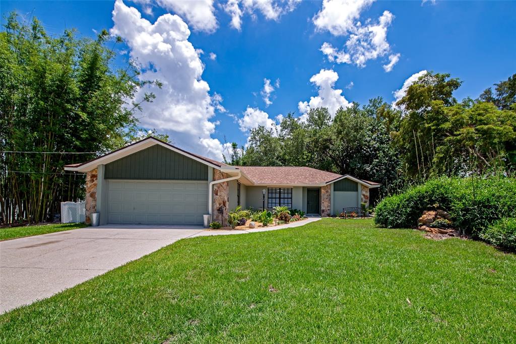 A single-story house with a two-car garage, stone accents, and a large front lawn — 6104 26TH AVENUE E, BRADENTON, FL