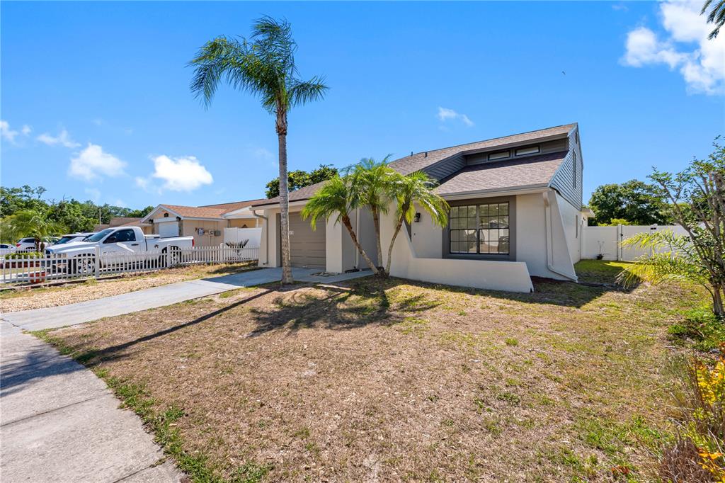 A single-story house with a white exterior, a garage, and palm trees in the front yard — 6419 MONTEREY BOULEVARD, TAMPA, FL