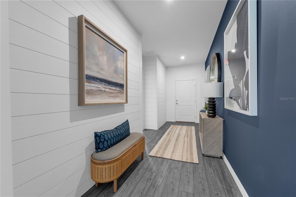 A modern entryway features white shiplap walls, a blue accent wall, and dark wood flooring — 3836 RISING TRAIL, DAVENPORT, FL