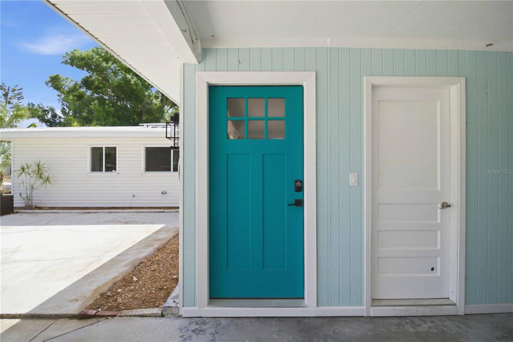 A teal door and a white door are set into a light blue exterior wall — 2816 MICHIGAN STREET, SARASOTA, FL