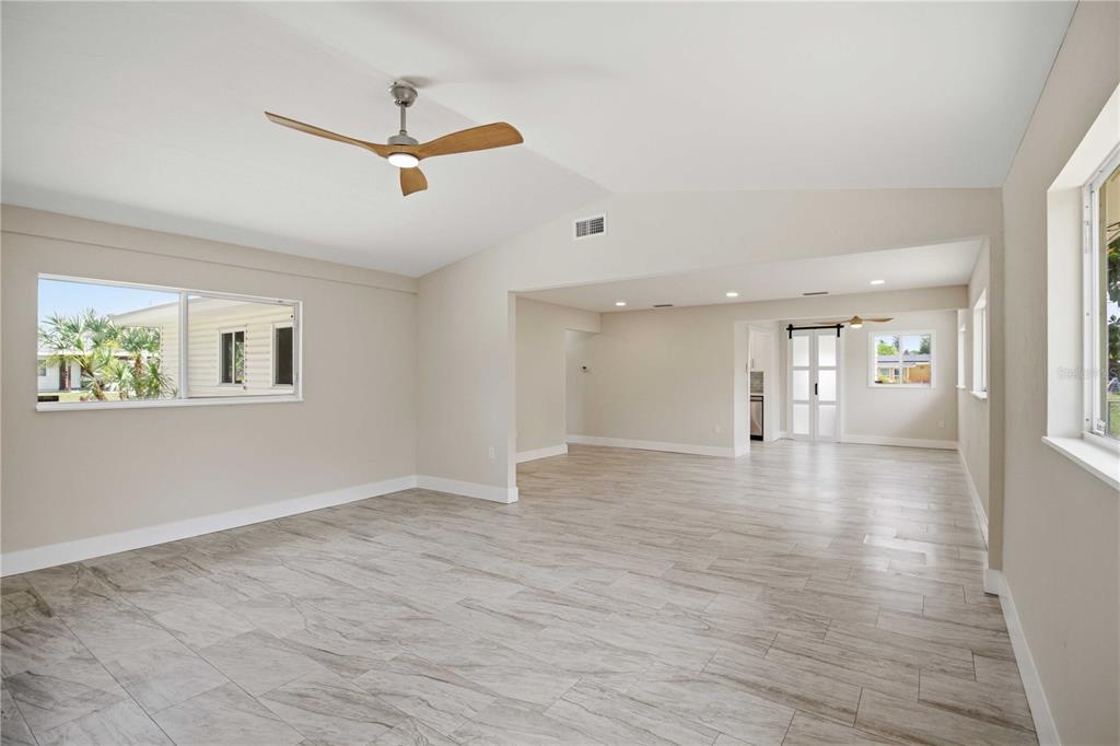 A spacious living area features light-colored tile flooring, a vaulted ceiling, and a ceiling fan — 2816 MICHIGAN STREET, SARASOTA, FL