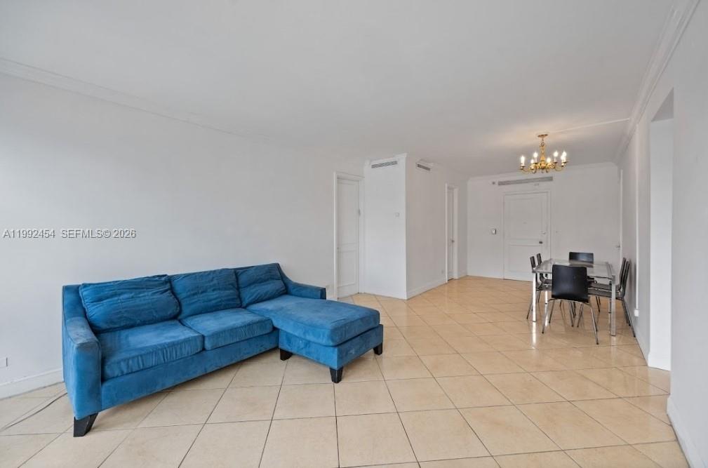 A living and dining room with a blue sectional sofa and beige tile flooring — 5055 Collins Ave # 2K, Miami Beach FL 33140, MIAMI BEACH, FL