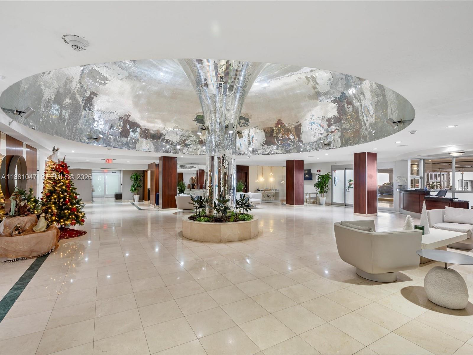 A spacious lobby features a central mirrored column, a large circular ceiling feature, and tile flooring — 2655 Collins Ave # 510, Miami Beach FL 33140, MIAMI BEACH, FL