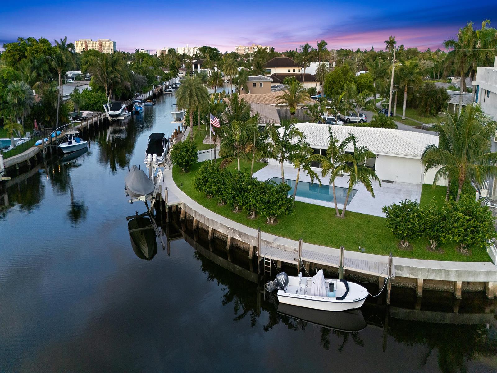 An aerial view of a waterfront home featuring a pool, lawn, and private boat dock — 2421 NE 50th Street, Lighthouse Point FL 33064, LIGHTHOUSE POINT, FL