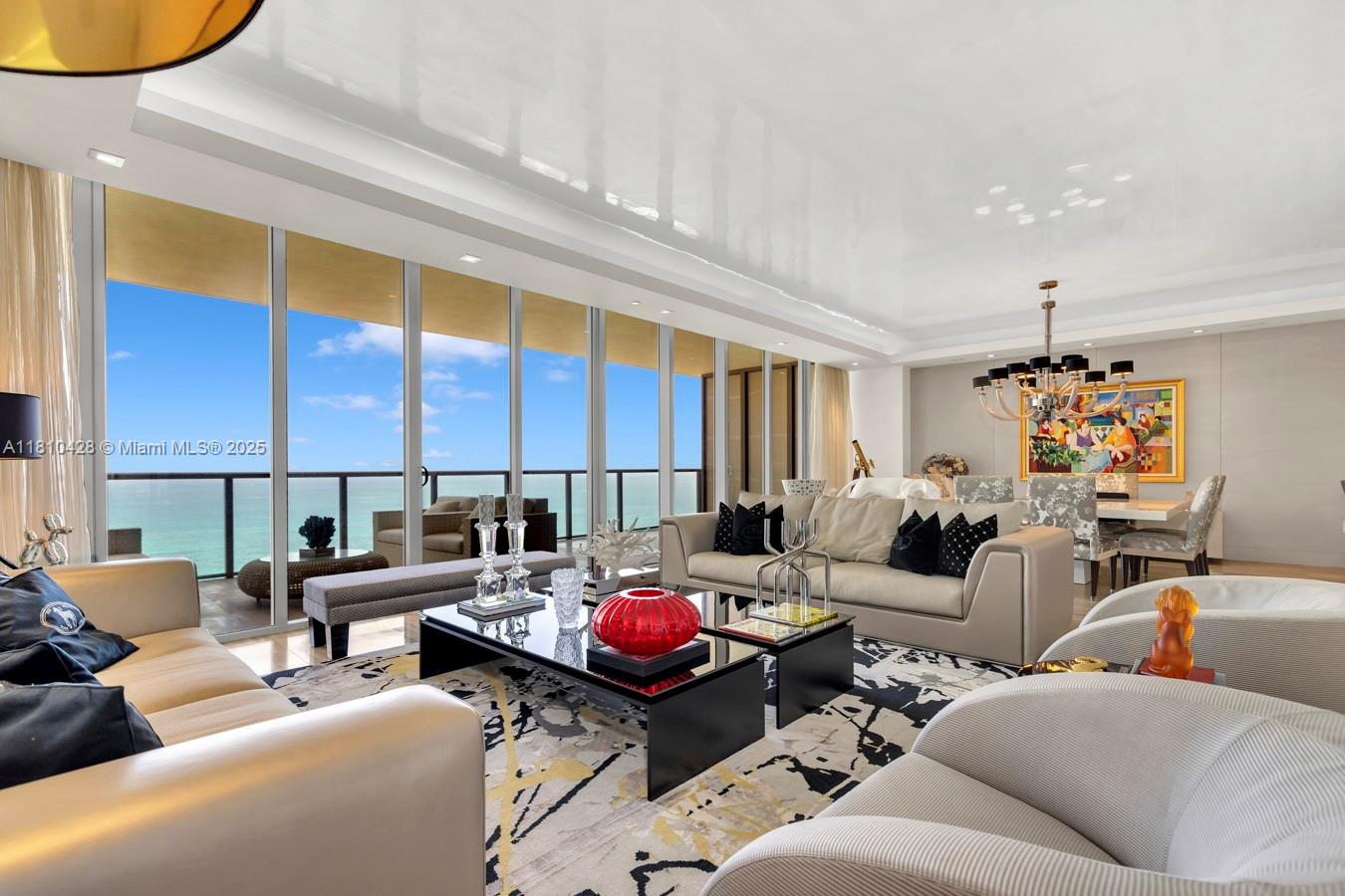 A modern living room features floor-to-ceiling windows with ocean views and a glossy ceiling — 9701 Collins Ave # 2403S, Bal Harbour FL 33154, BAL HARBOUR, FL