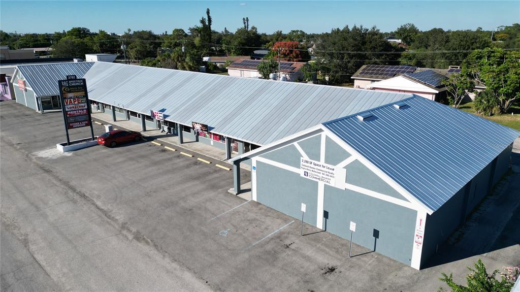 An aerial view shows a commercial strip mall with a metal roof and parking lot — 3762 TAMIAMI TRAIL UNIT H, PORT CHARLOTTE, FL