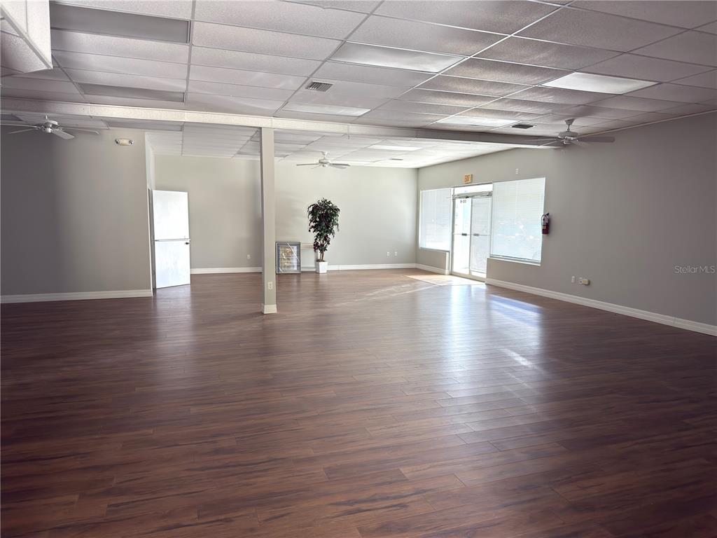 A large, open commercial space features wood-look flooring, a drop ceiling, and a support column — 3762 TAMIAMI TRAIL UNIT H, PORT CHARLOTTE, FL