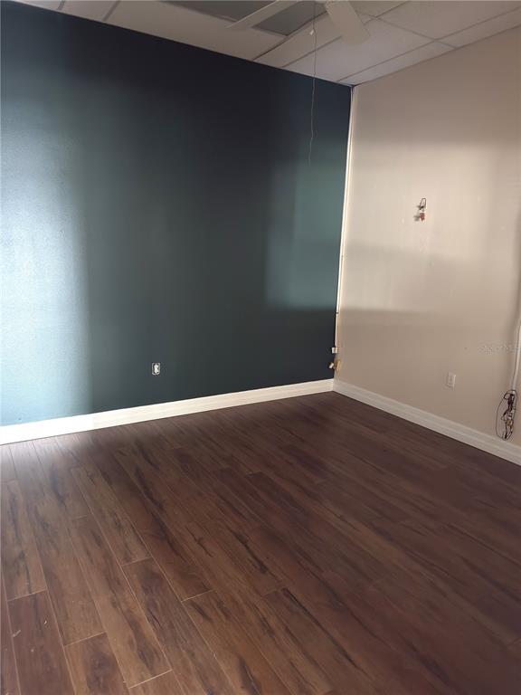 An interior room features dark teal and beige walls, wood-look flooring, and a ceiling fan — 3762 TAMIAMI TRAIL UNIT H, PORT CHARLOTTE, FL