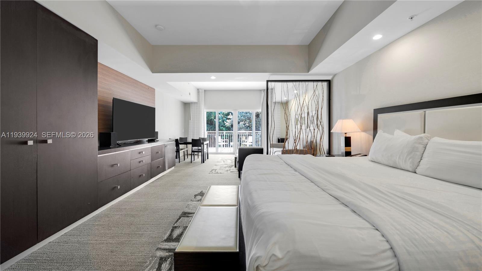 A bedroom features a large bed, dark cabinetry, a television, and a balcony view — 5300 NW 87th Ave # 1510, Doral FL 33178, DORAL, FL