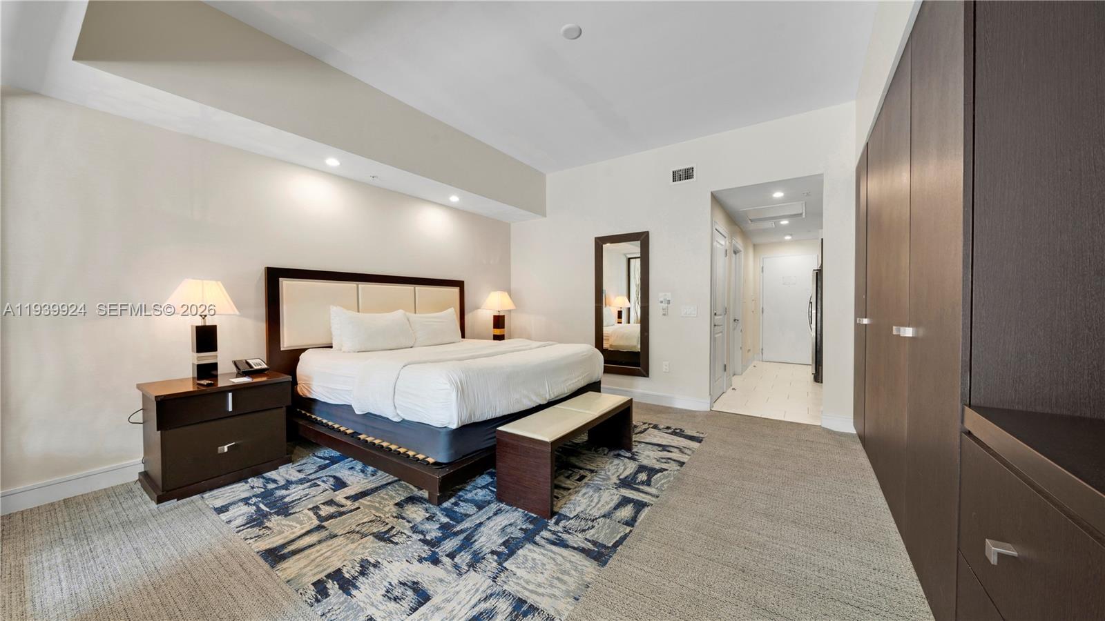 A bedroom features a king bed, a patterned area rug, and a large wardrobe — 5300 NW 87th Ave # 1510, Doral FL 33178, DORAL, FL