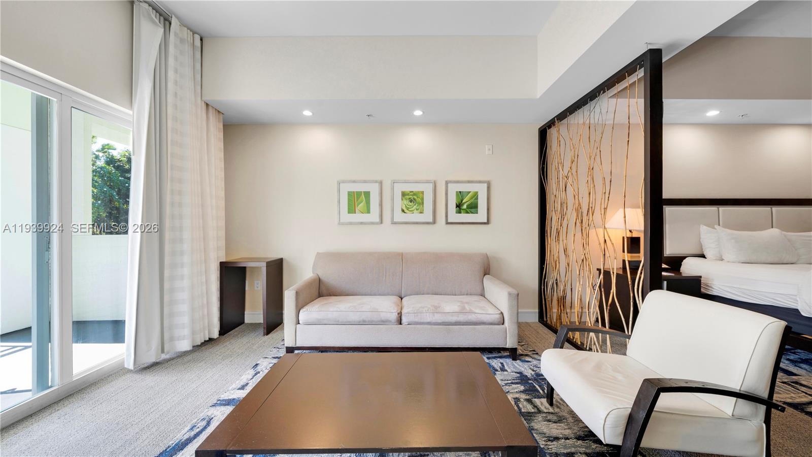 A living area features a beige sofa, a white armchair, and a decorative branch partition — 5300 NW 87th Ave # 1510, Doral FL 33178, DORAL, FL