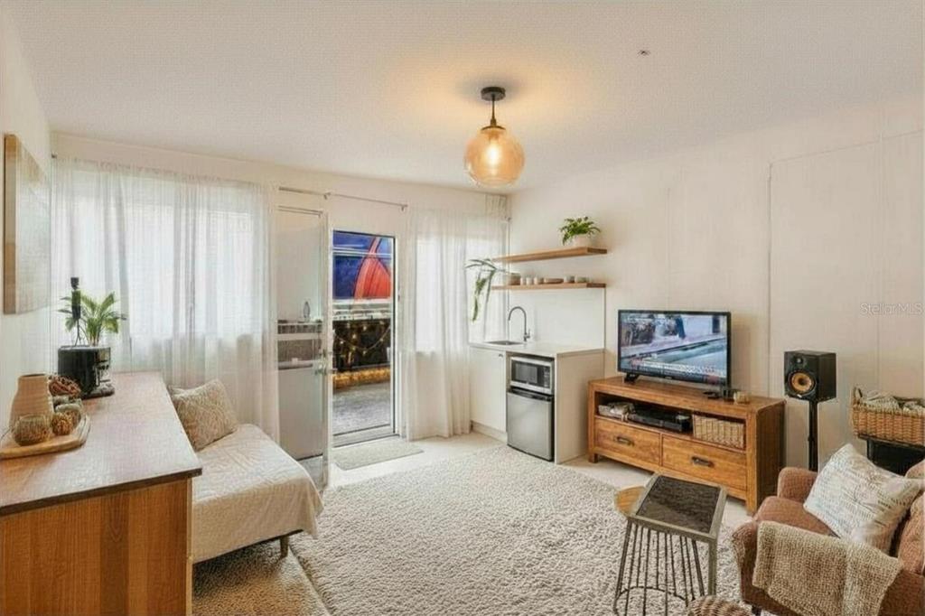 A living room with a kitchenette, a television, a sofa, and a glass door to a balcony — 1829 5TH, MIAMI, FL