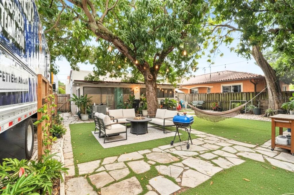 A backyard patio features a stone walkway, artificial turf, outdoor seating, and a hammock — 1829 5TH, MIAMI, FL