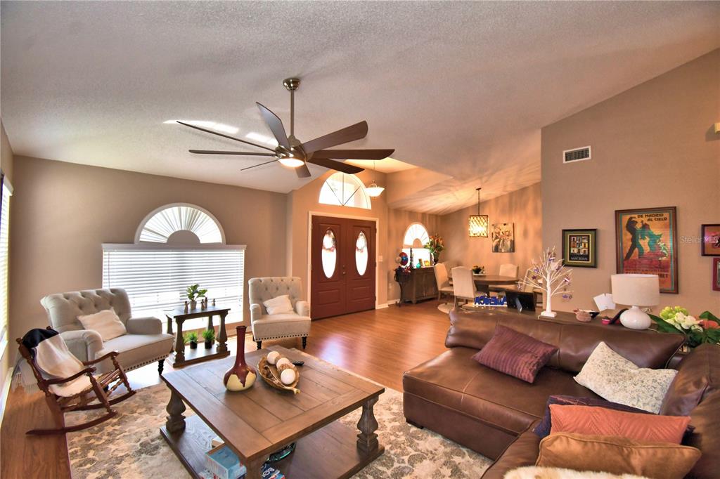 A living room with a brown leather sofa, wood coffee table, and two armchairs — 659 SIERRA CIRCLE, DAVENPORT, FL