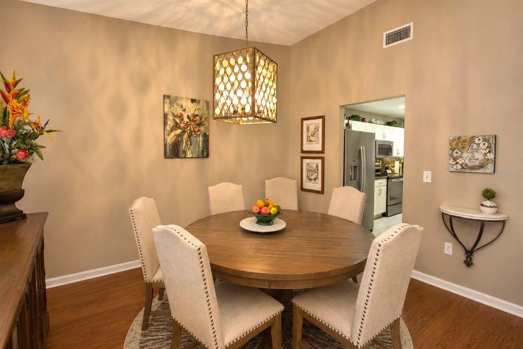 A dining room features a round wooden table, upholstered chairs, and a decorative pendant light — 659 SIERRA CIRCLE, DAVENPORT, FL