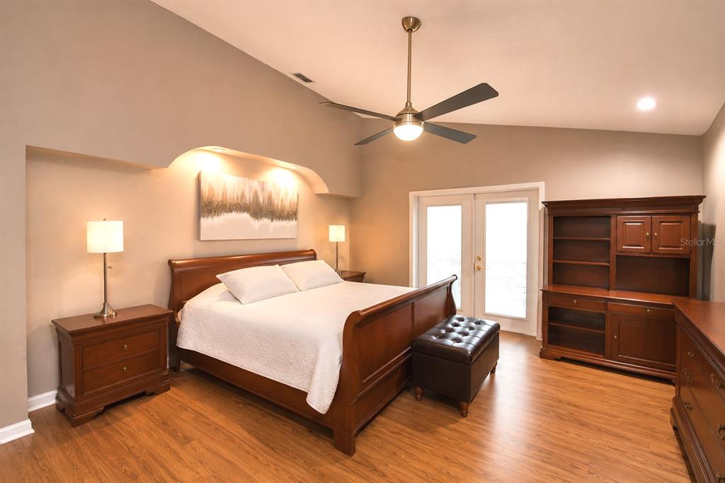 A bedroom features a wooden sleigh bed, a ceiling fan, and a large wooden hutch — 659 SIERRA CIRCLE, DAVENPORT, FL