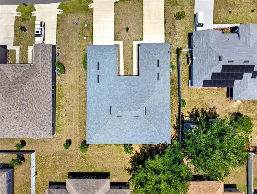 An aerial view shows a residential house with a gray shingled roof and a driveway — 36 LOUISBURG LANE UNIT A & B, PALM COAST, FL