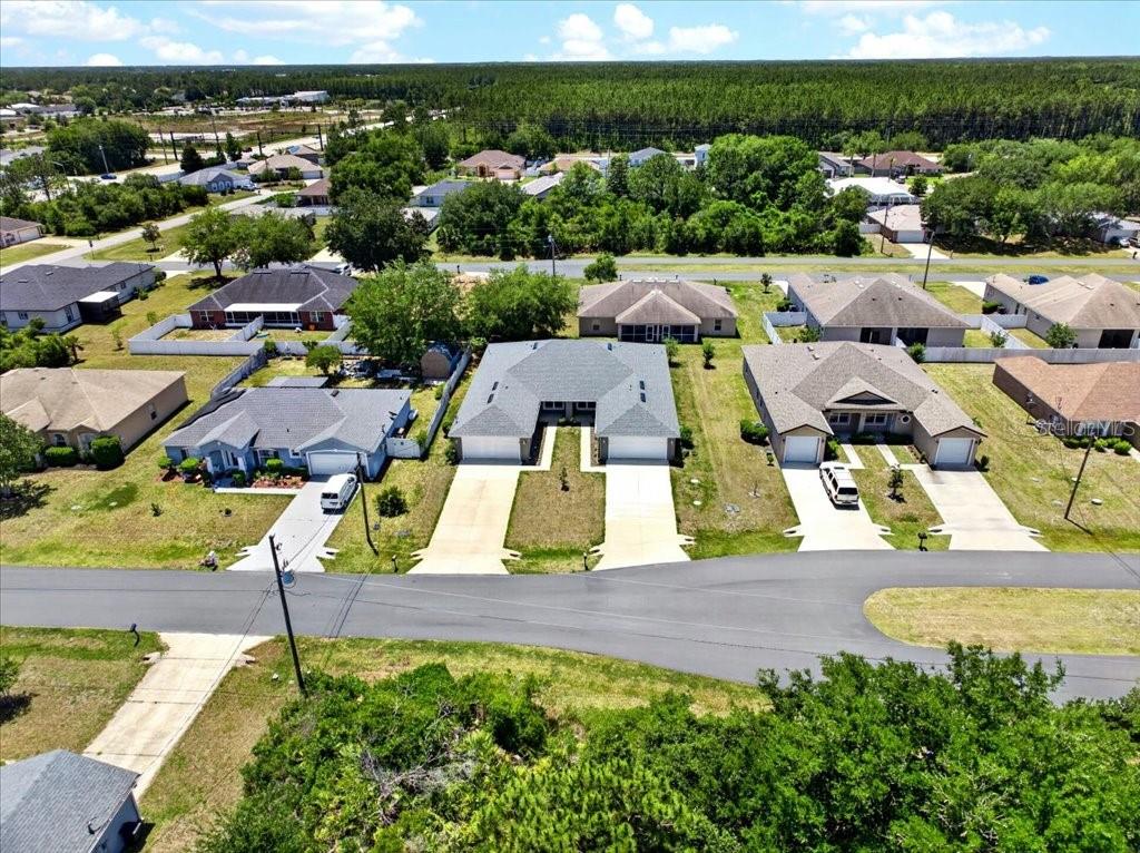 An aerial view shows a suburban street with several single-family homes and driveways — 36 LOUISBURG LANE UNIT A & B, PALM COAST, FL