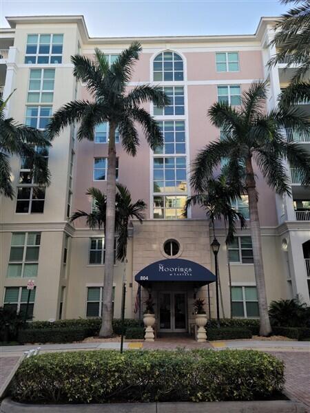 A multi-story pink and cream apartment building features palm trees and a blue entrance awning — 804 E Windward Way # 508, Lantana FL 33462, LANTANA, FL
