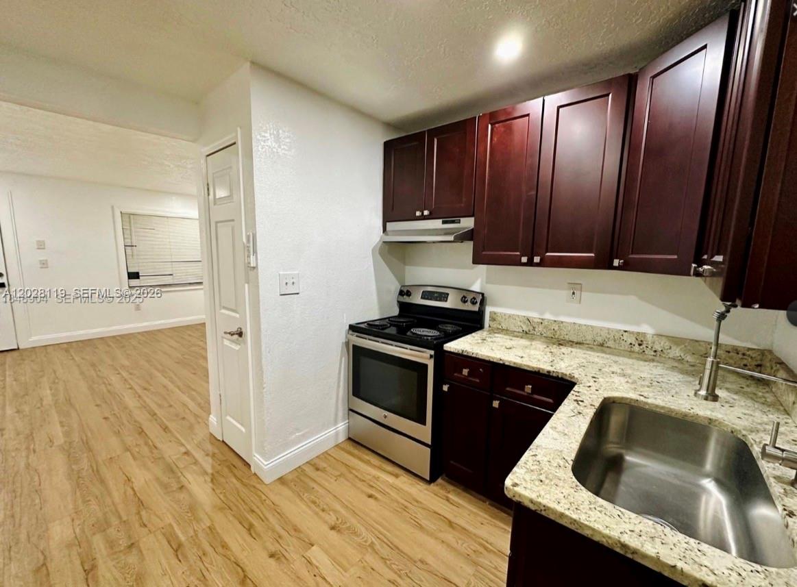 A kitchen features dark wood cabinets, granite countertops, and stainless steel appliances — 813 W Jefferson ST # 5, Orlando FL 32805, ORLANDO, FL