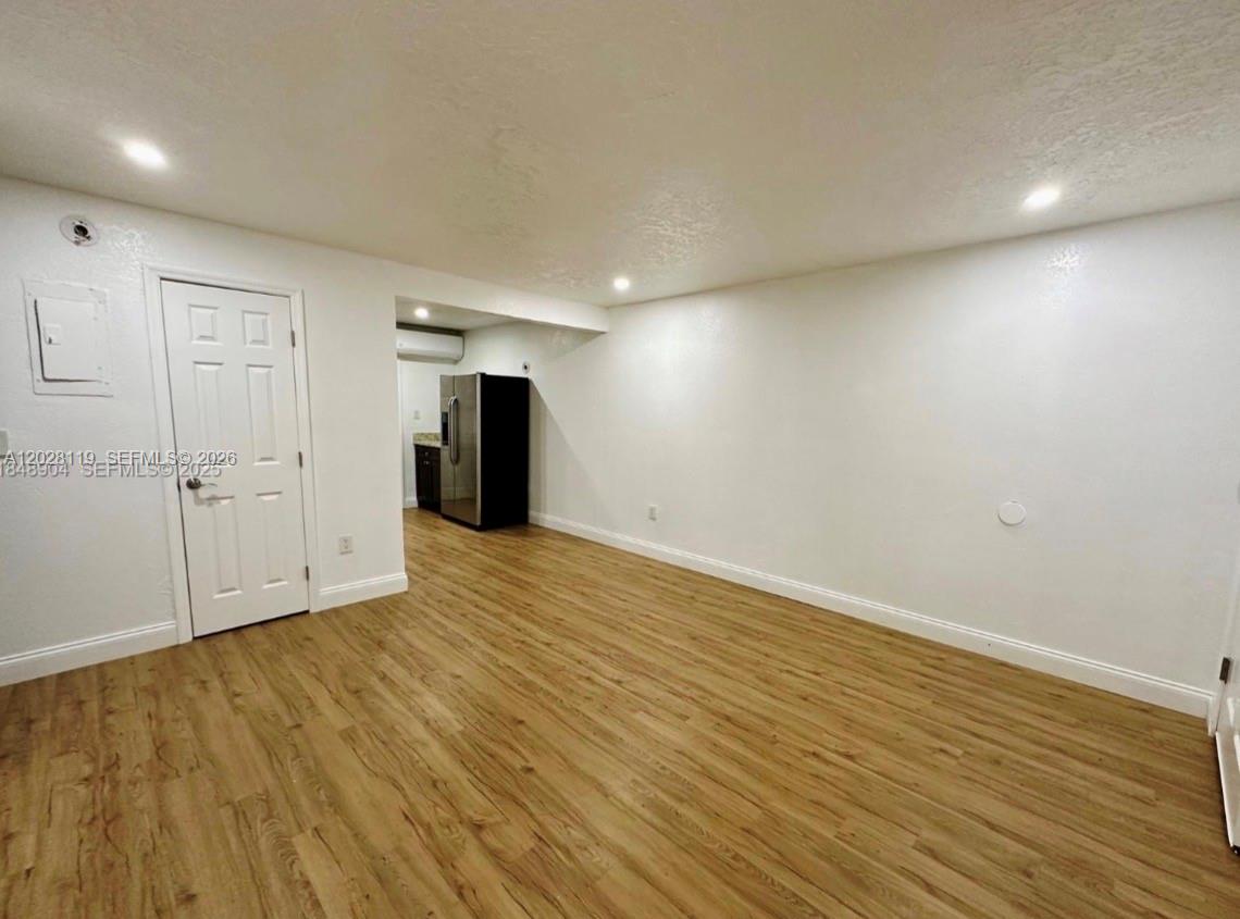 An empty room features light wood-look flooring, white walls, and a white door — 813 W Jefferson ST # 5, Orlando FL 32805, ORLANDO, FL