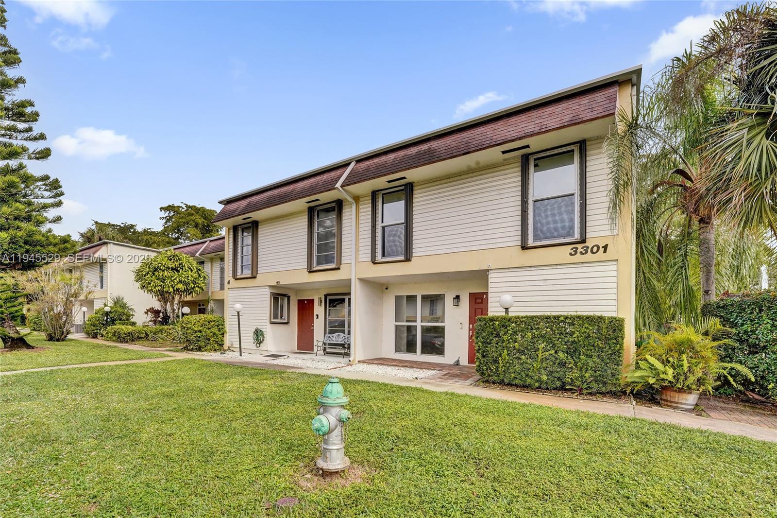 A two-story residential building with light-colored siding and a fire hydrant in the front yard — 3301 Raleigh St # 4E, Hollywood FL 33021, HOLLYWOOD, FL