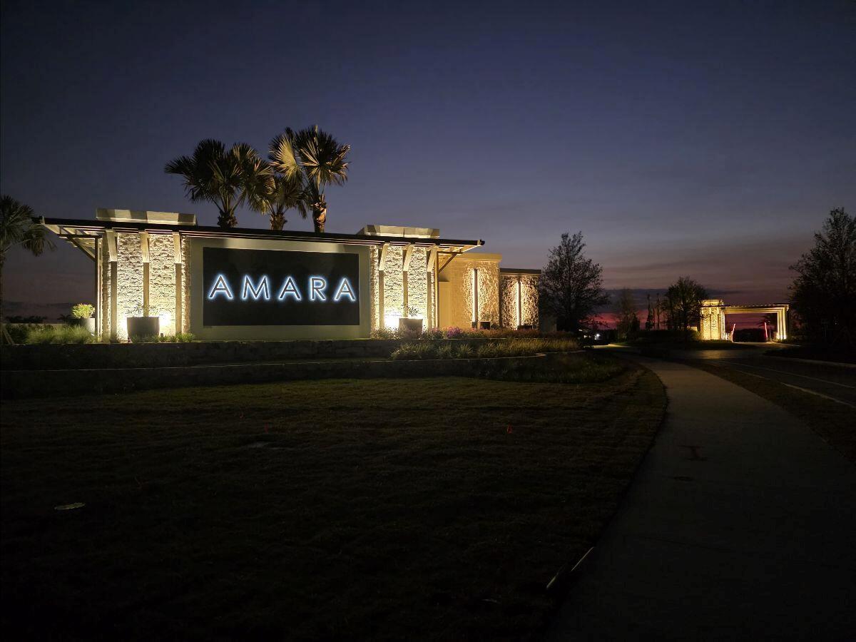 The illuminated entrance sign for Amara stands at dusk beside a paved walkway — 10180 Amara Ranch Drive, Lake Worth FL 33449, LAKE WORTH, FL