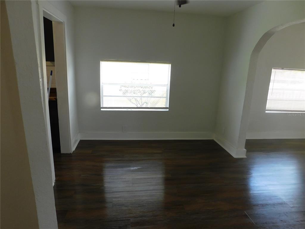 A room with dark wood-look flooring, white walls, two windows, and an arched doorway — 1009 17TH STREET S, ST PETERSBURG, FL