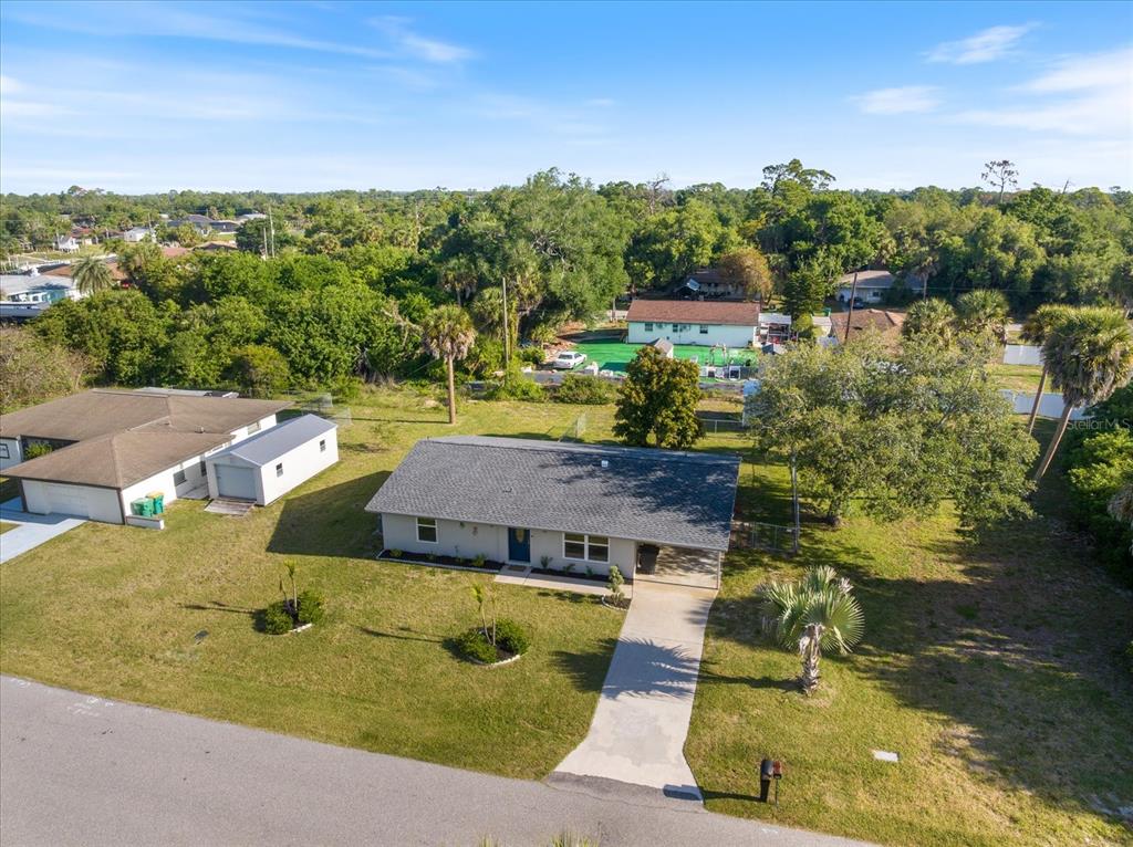 An aerial view of a single-story house with a gray roof and a concrete driveway — 1184 BARBOUR AVENUE, PORT CHARLOTTE, FL