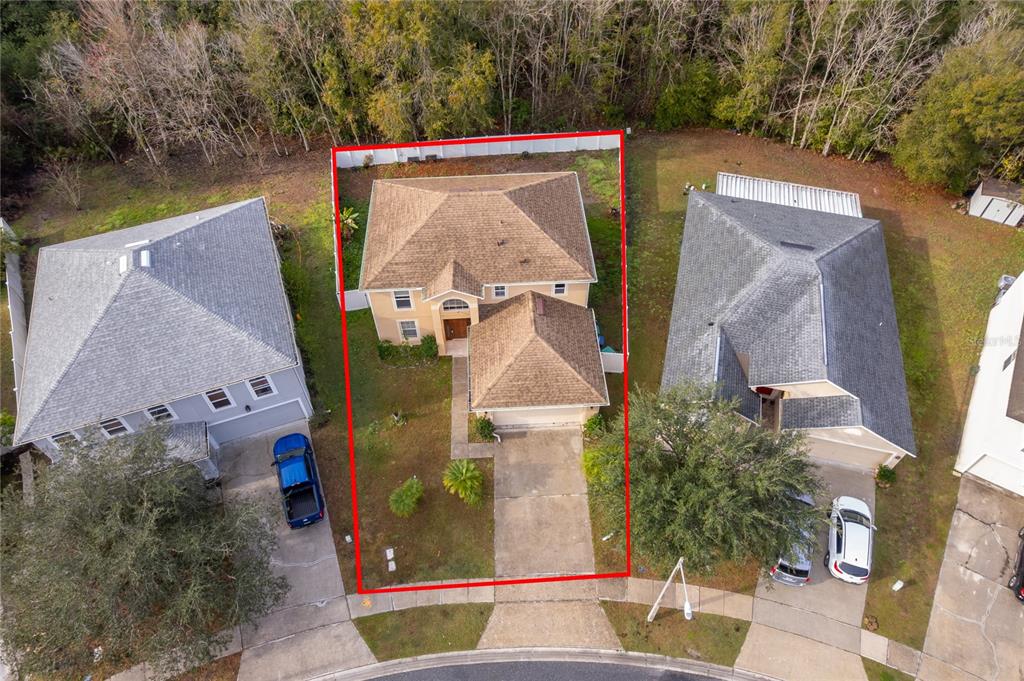 An aerial view shows a two-story house with a brown roof and a concrete driveway — 10409 LAXTON STREET, ORLANDO, FL