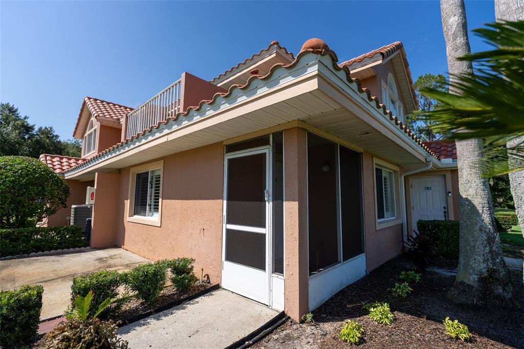 A peach-colored house exterior features a screened-in porch, a balcony, and a tiled roof — 5203 WATERVIEW WAY UNIT 5203, WINTER HAVEN, FL