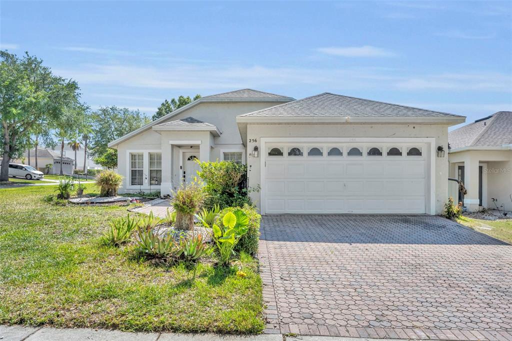 A single-story house with a paved driveway, a two-car garage, and a landscaped front yard — 256 HERRING STREET, DAVENPORT, FL