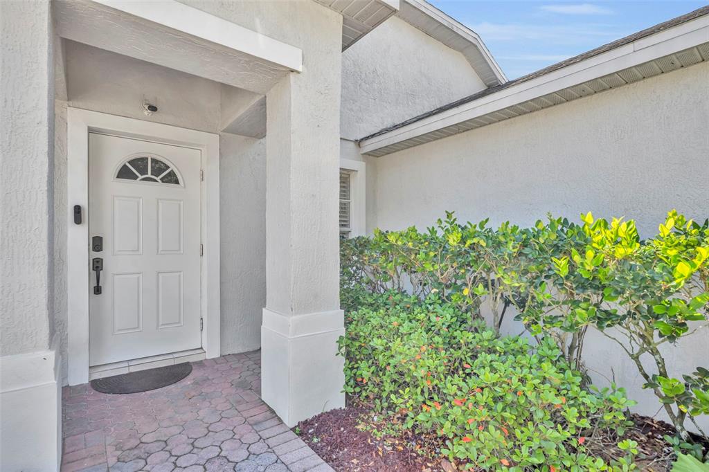 A white front door with a semi-circular window is set in a stucco entryway — 256 HERRING STREET, DAVENPORT, FL
