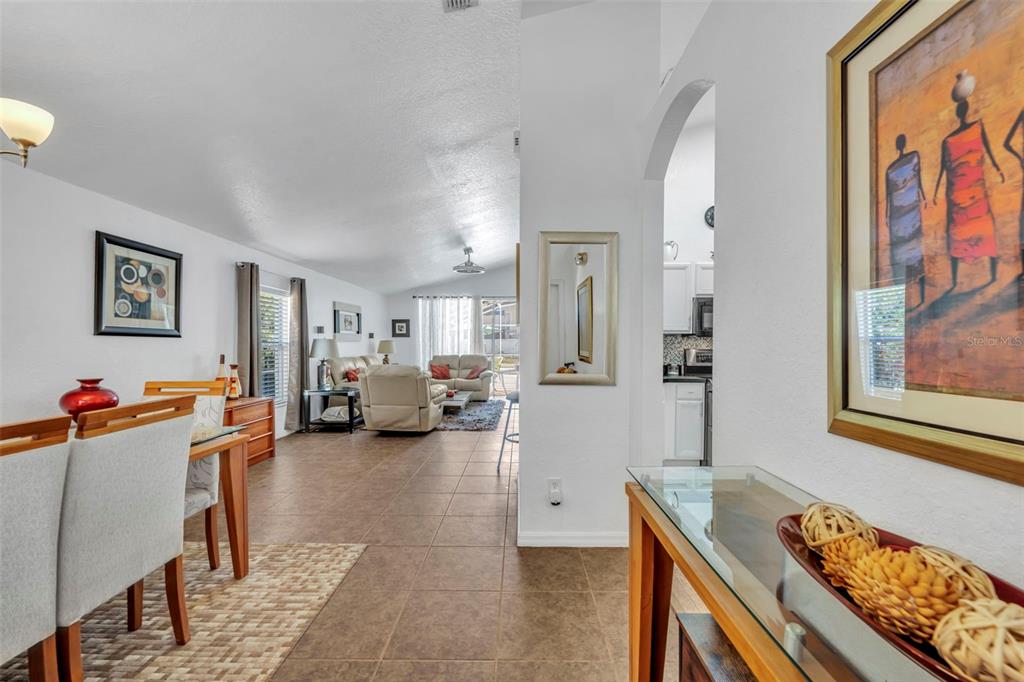 A view from a hallway looking into an open-concept living and dining area with tile floors — 256 HERRING STREET, DAVENPORT, FL