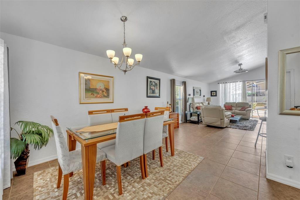 A dining area with a glass-topped table and chairs opens into a living room — 256 HERRING STREET, DAVENPORT, FL