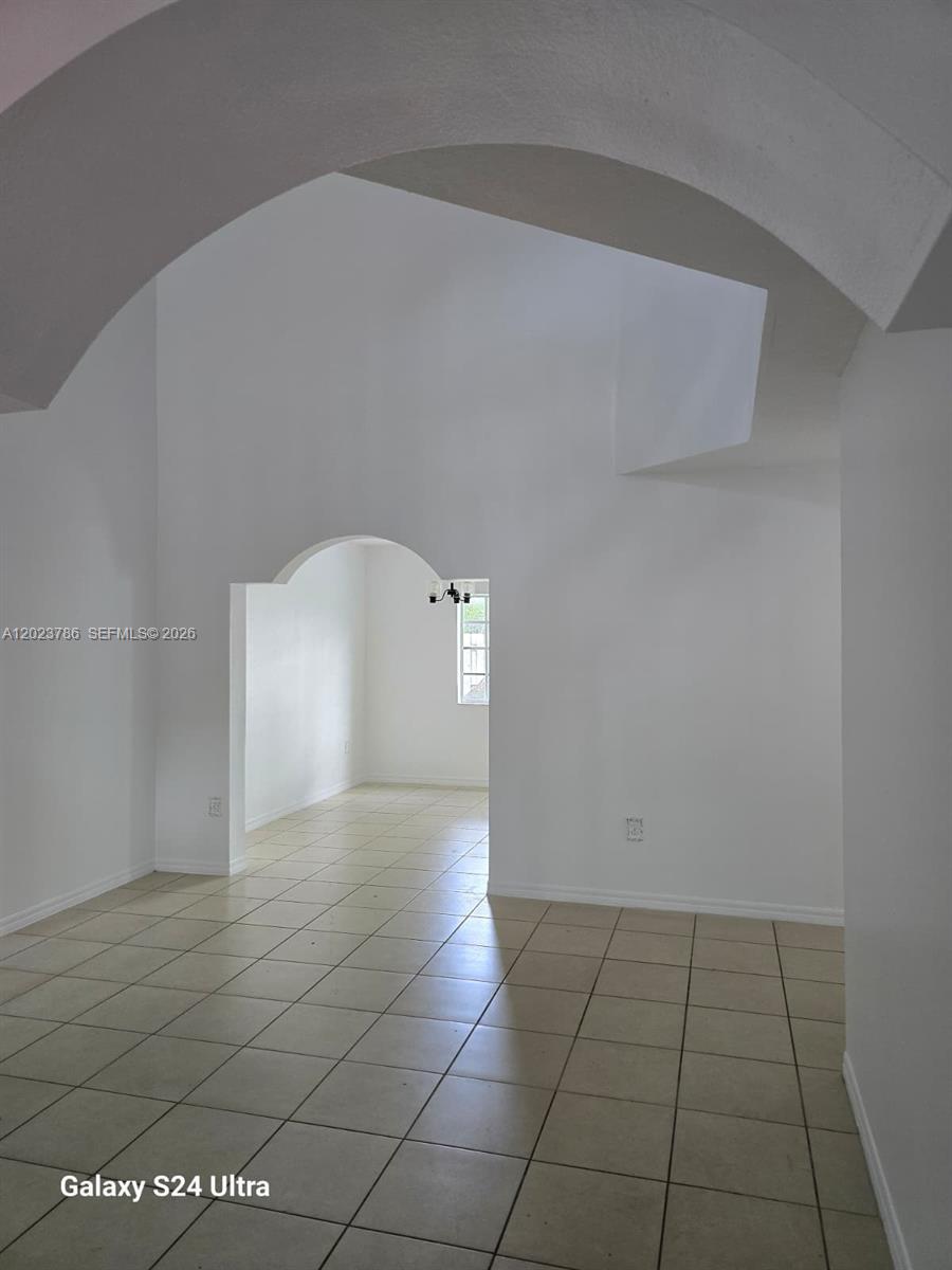 An interior view shows a tiled room with high ceilings and an arched doorway — 13658 SW 142nd Ter # 13658, Miami FL 33186, MIAMI, FL