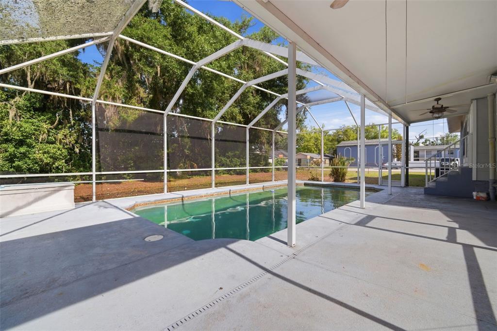 A screened-in patio features a rectangular swimming pool and a concrete deck — 1201 W REYNOLDS STREET, PLANT CITY, FL