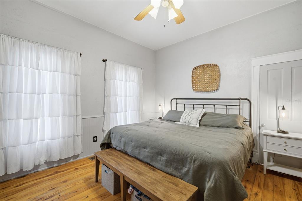 A bedroom features a metal bed frame, wooden floors, and white ruffled curtains — 1201 W REYNOLDS STREET, PLANT CITY, FL
