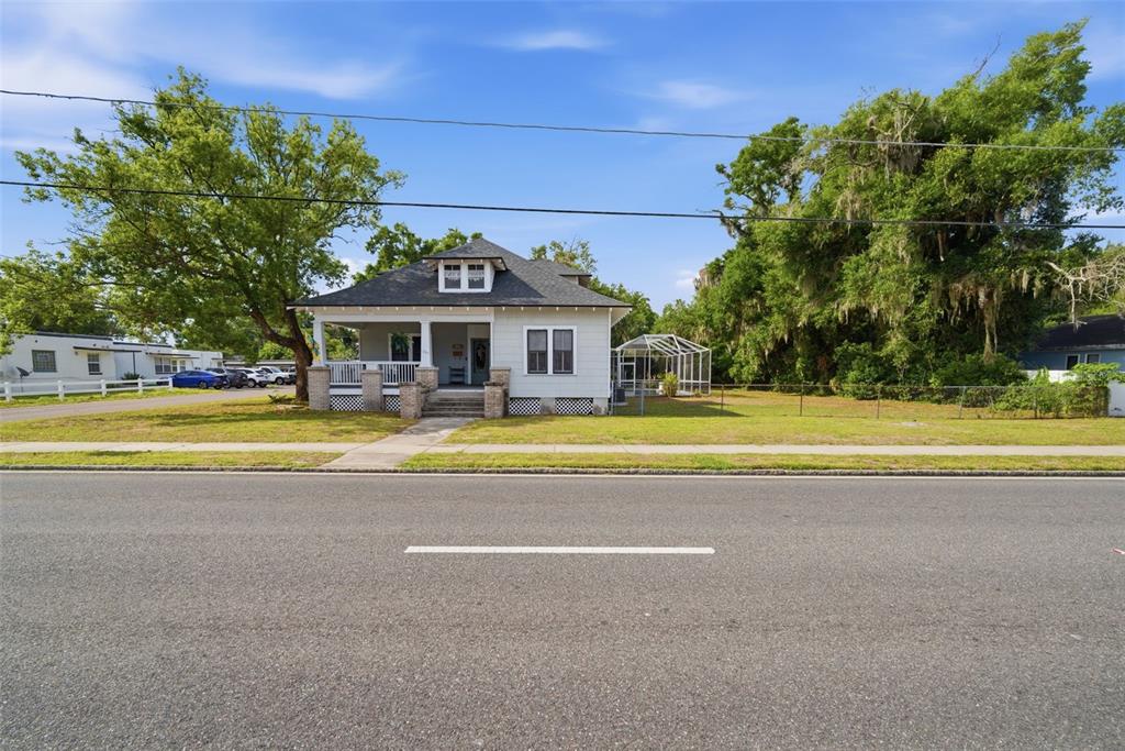 A light-colored, single-story house with a front porch and a screened-in patio area — 1201 W REYNOLDS STREET, PLANT CITY, FL