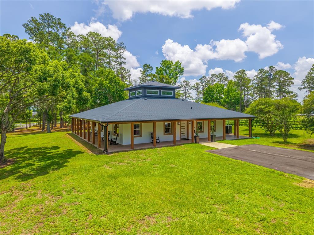 A single-story house with a wrap-around porch and a central cupola sits on a lawn — 6450 NW HIGHWAY 225, OCALA, FL
