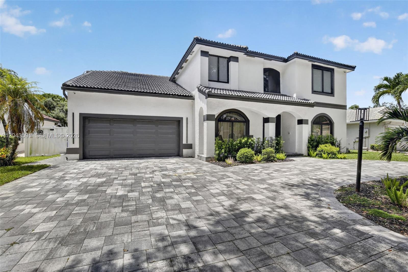 A two-story white house with a gray tile roof and a paved driveway — 10746 Charleston Pl, Cooper City FL 33026, COOPER CITY, FL
